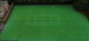 Aerial view of green MUGA surfacing with multi-sport line markings for tennis, football, and netball.